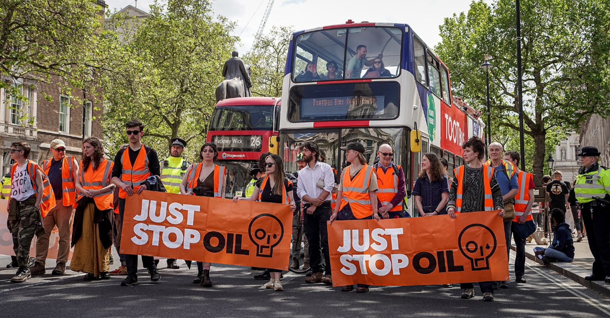 Just Stop Oil activists walking up Whitehall towards Trafalgar Square on Saturday 20 May 2023. Photograph by Alisdare Hickson. (Wikimedia Commons).