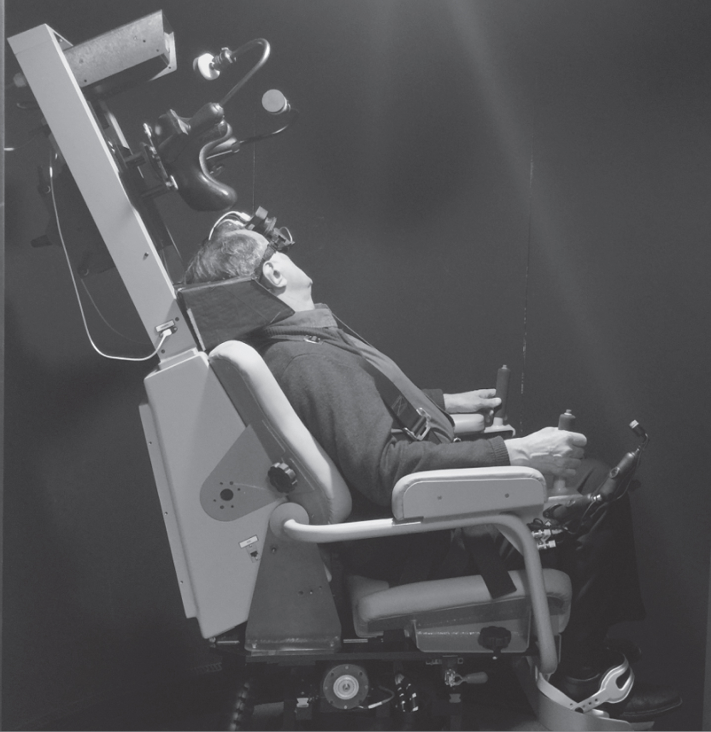 Subject seated in the computerized rotational head impulse test (crHIT) device. The subject is seated in the LARP testing position, which requires the LARP plane to be earth-horizontal because the axis of rotation of the crHIT device is earth-vertical.